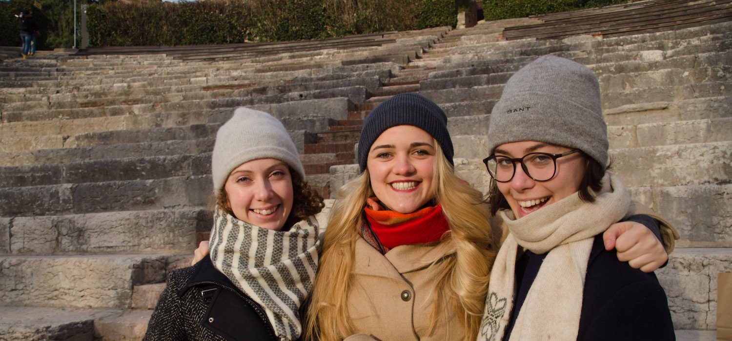 young tutors wrapped up in hats and scarves in the amphitheatre in Verona, Italy