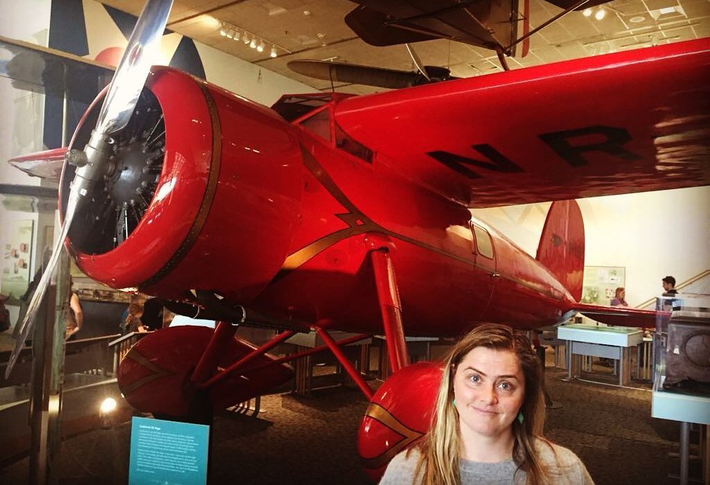 alumni Molly in front of Amelia Earhart's Little Red Bus